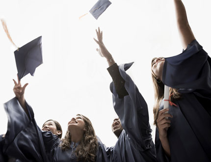 Students Throwing Up Their Cap and Gown At Graduation Photo